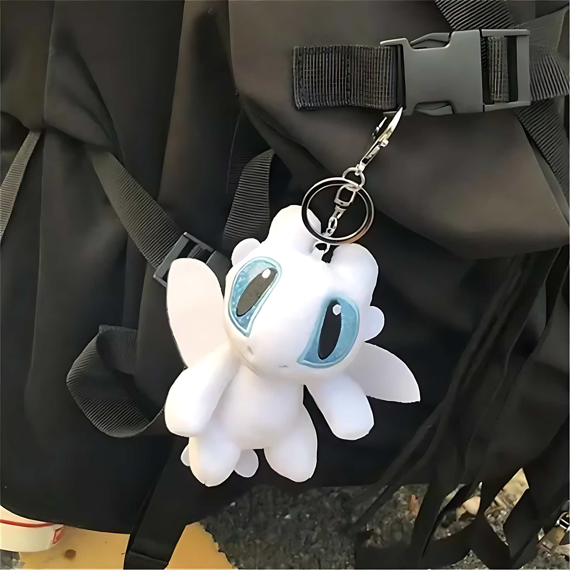 White plush dragon keychain hanging on a bag